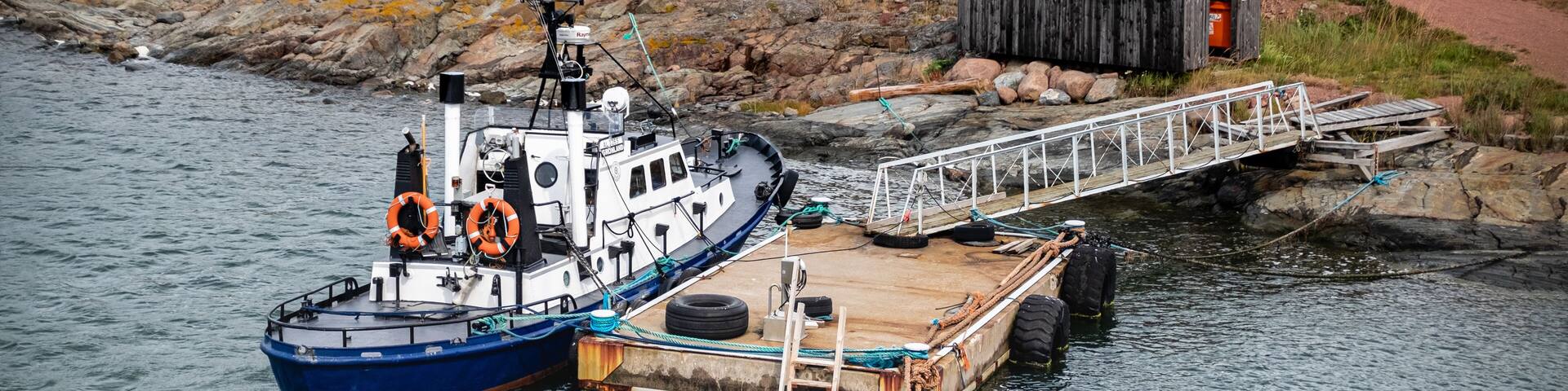 Aland Islands, Finland, Mariehamn, Sottunga August 2019: berth of the island and tug moored to the port of sottung on the Parking lot, moored ship.