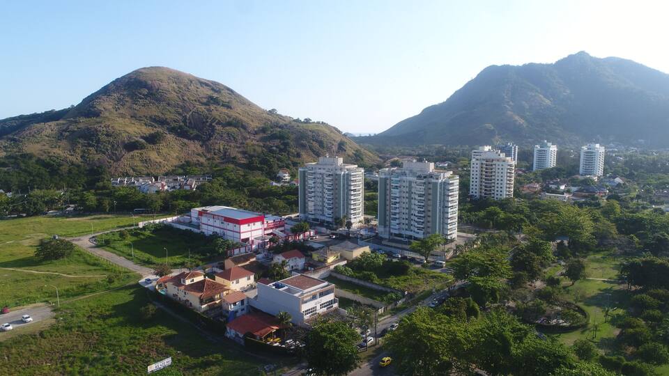 A residential area with high-rise buildings, a red building, and a mountainous landscape.
