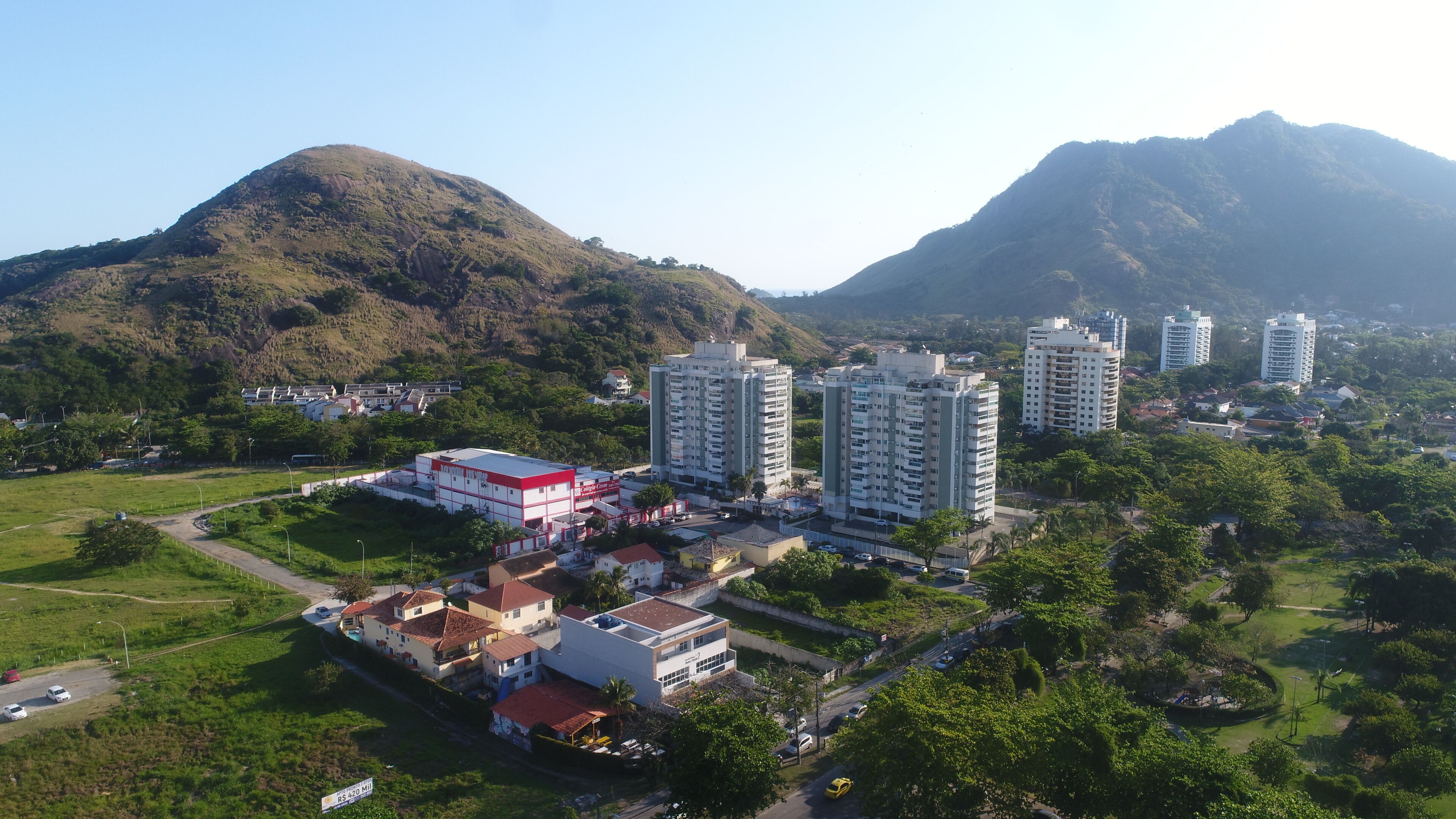 A residential area with high-rise buildings, a red building, and a mountainous landscape.