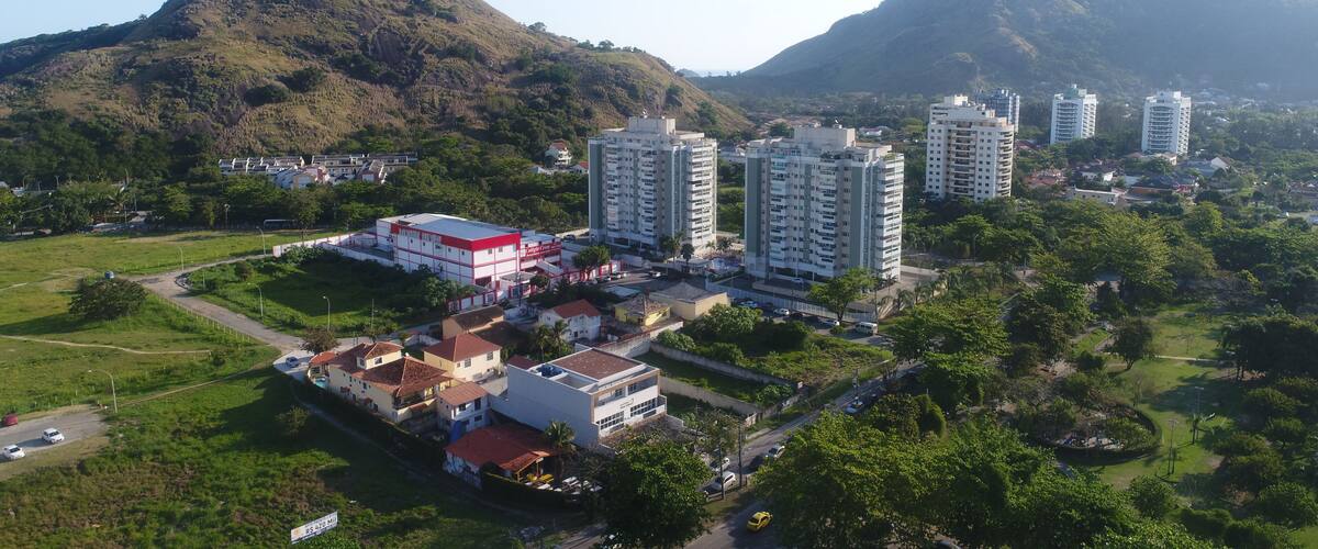 A residential area with high-rise buildings, a red building, and a mountainous landscape.