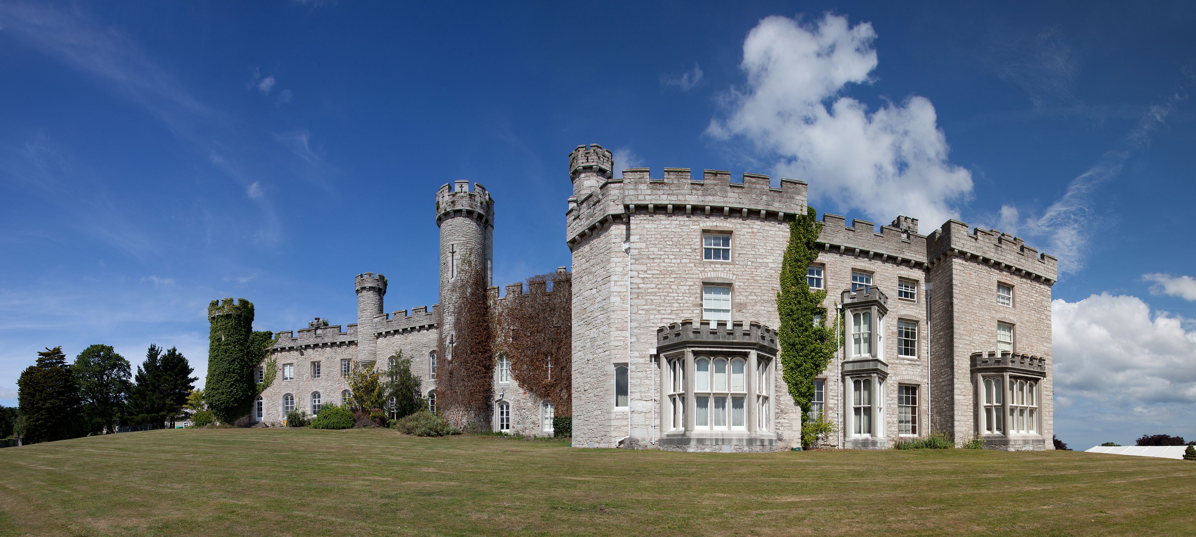 A large stone castle with multiple towers and ivy-covered walls.
