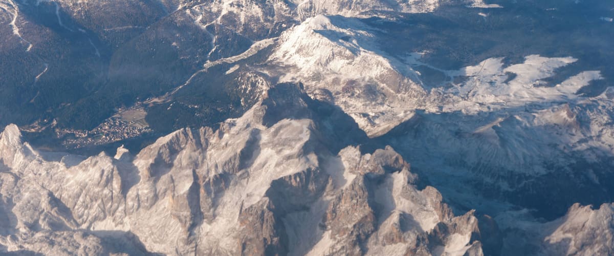 Rugged mountain peaks with snow-covered slopes and a valley below.