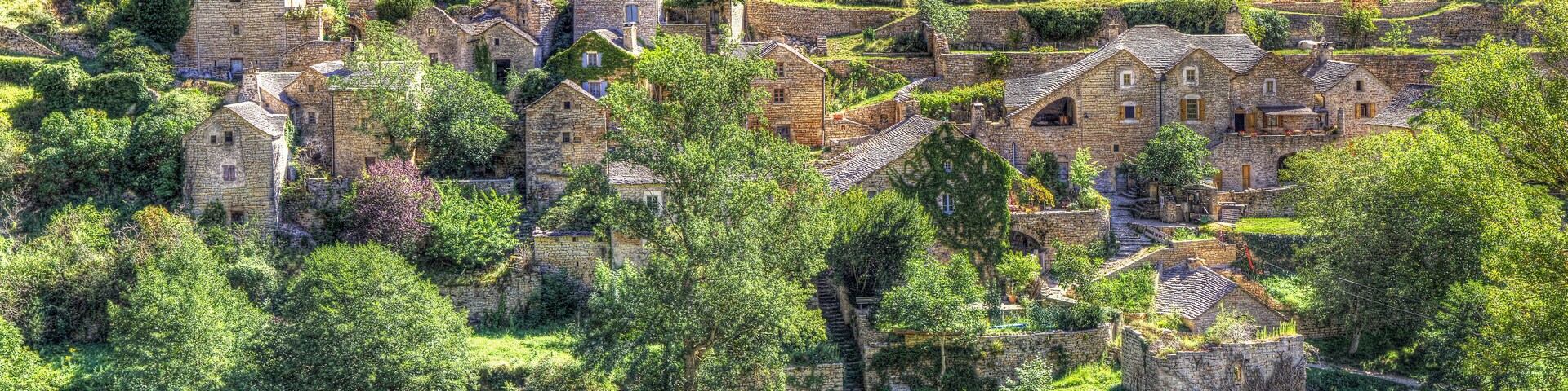 A historic village with stone buildings nestled in a lush valley.