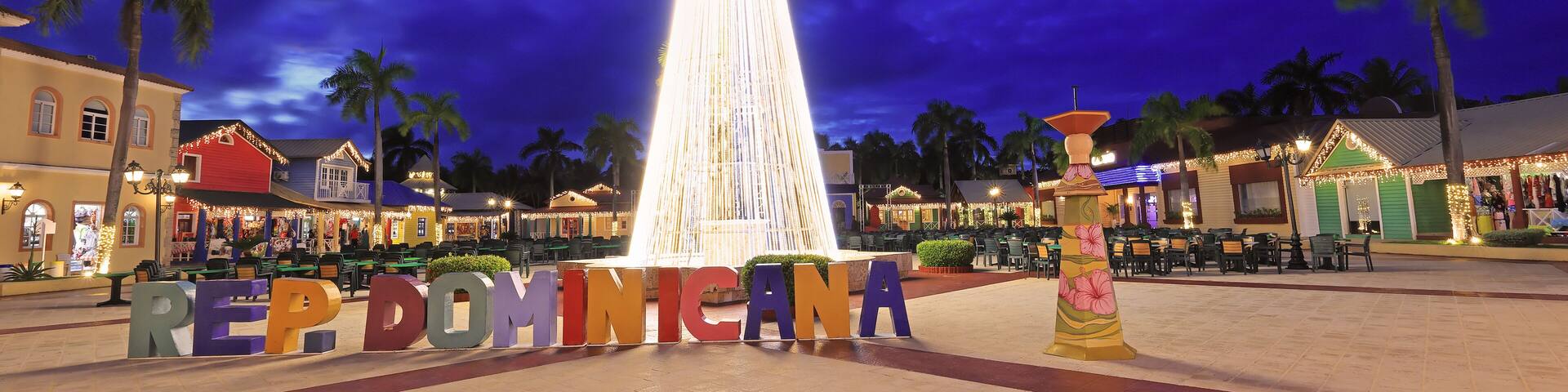 Beautiful illuminated Christmas Tree, Dominican Republic sign and shopping center square at dusk in Punta Cana