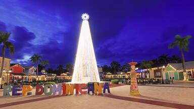 Beautiful illuminated Christmas Tree, Dominican Republic sign and shopping center square at dusk in Punta Cana