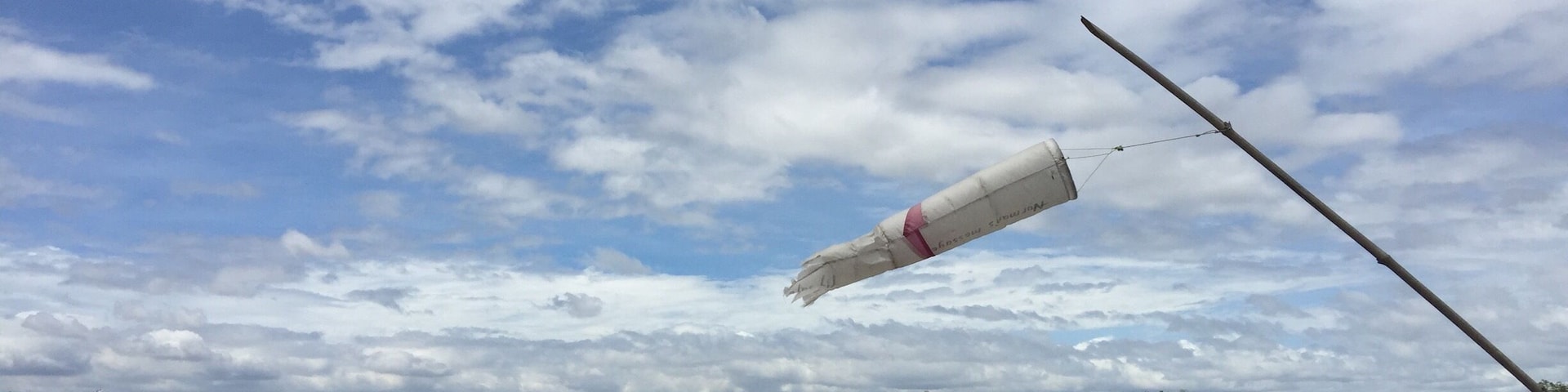 A field with a kite flying in the sky.