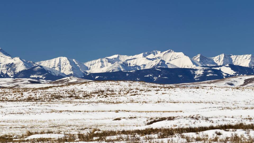 A snow-covered mountainous landscape with clear blue skies.