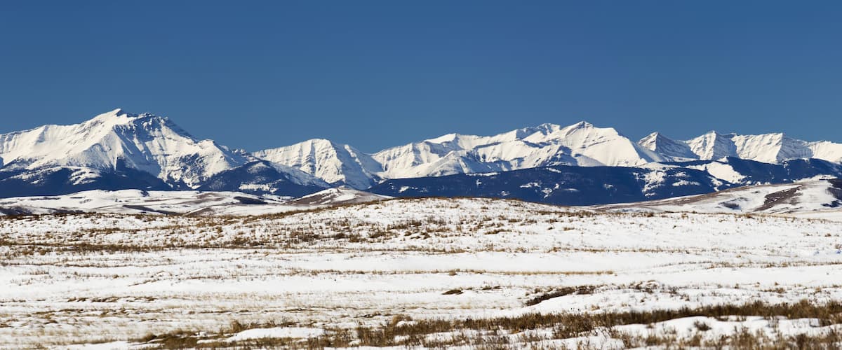 A snow-covered mountainous landscape with clear blue skies.