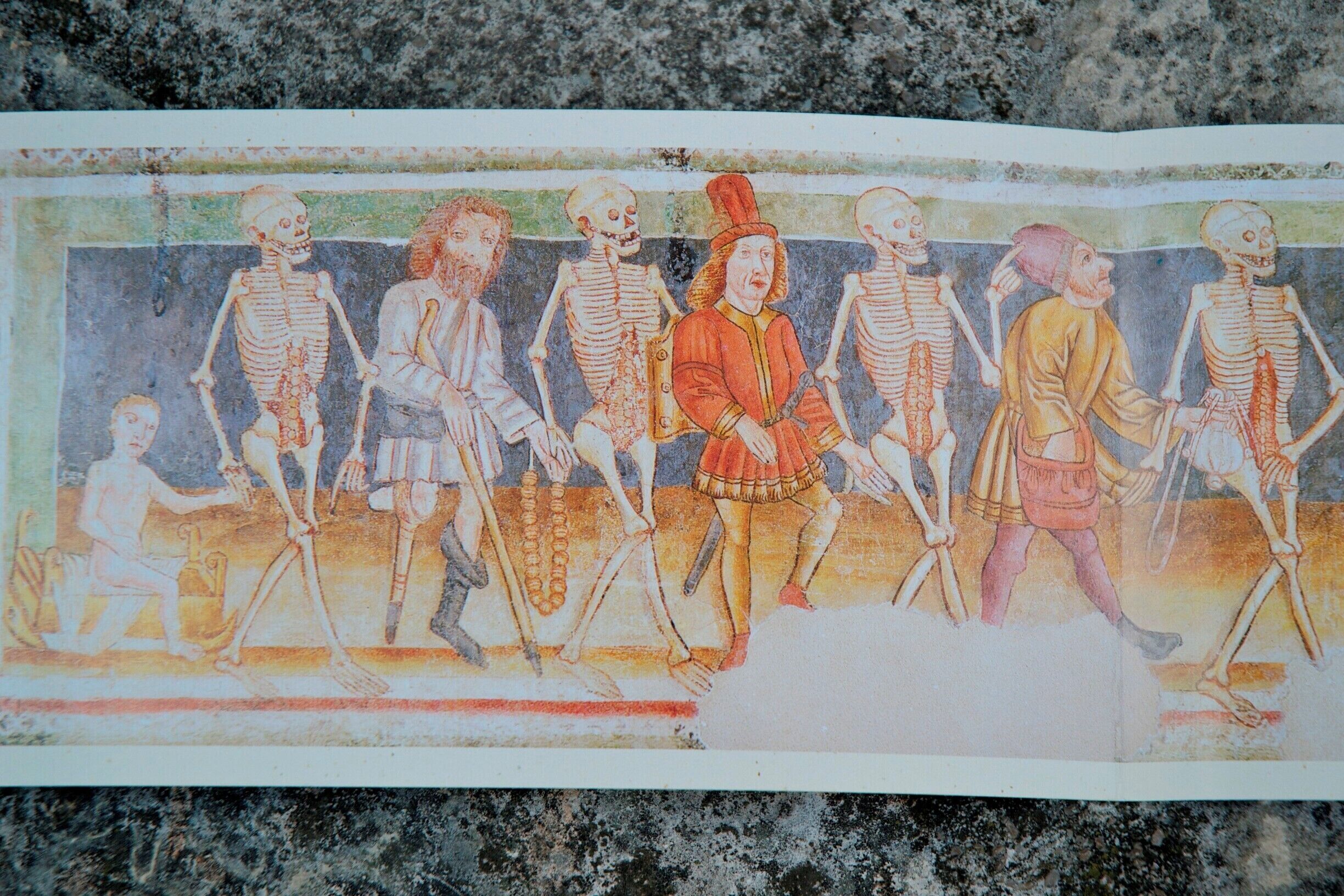 A historical illustration of skeletons and figures in period clothing.