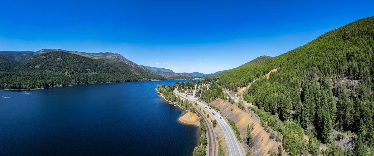 A lake surrounded by mountains and a highway.