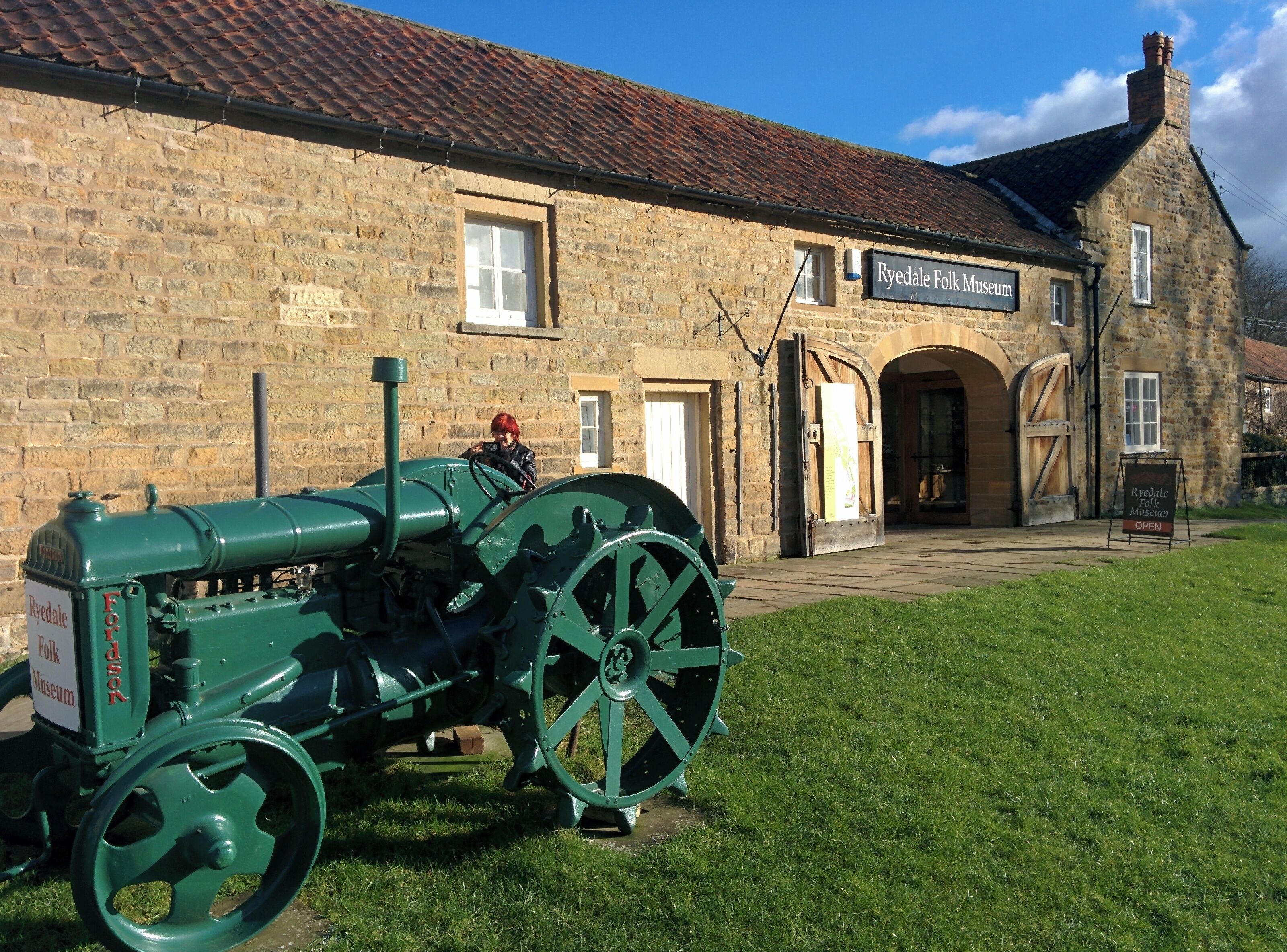 A green tractor in front of the Ryedale Folk Museum.