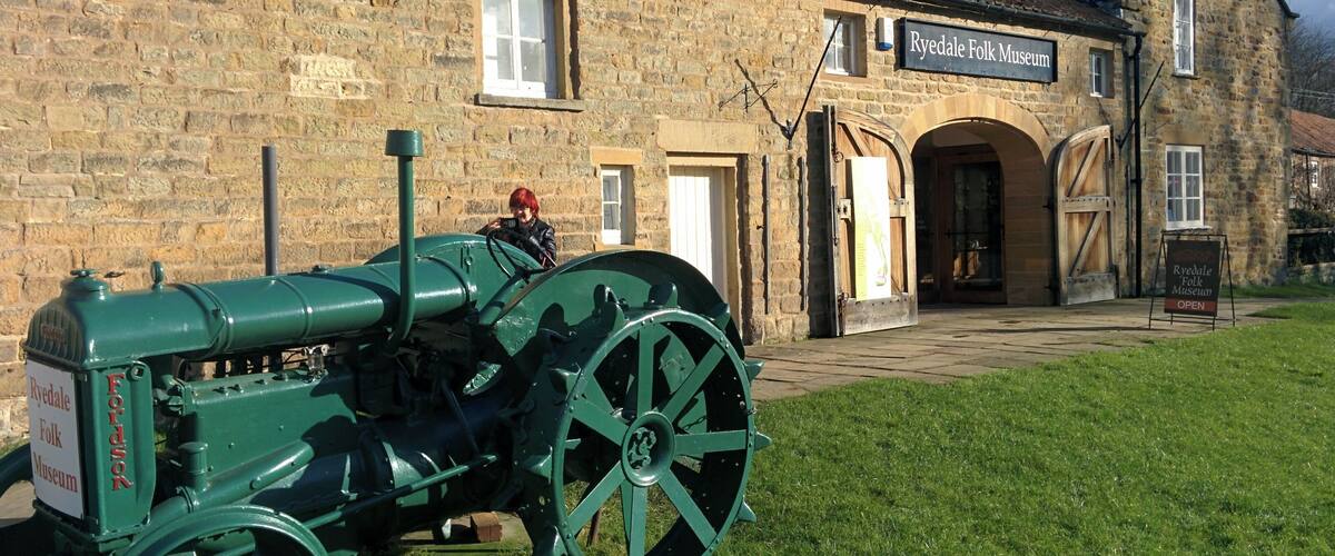 A green tractor in front of the Ryedale Folk Museum.