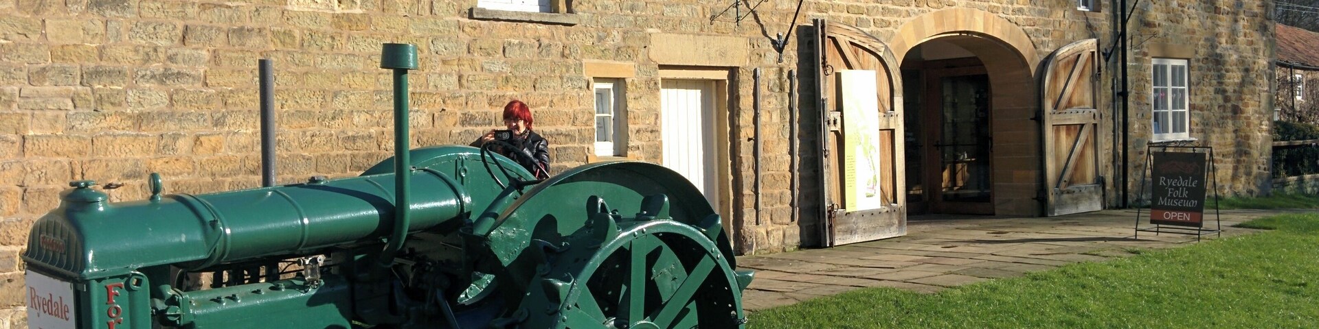 A green tractor in front of the Ryedale Folk Museum.