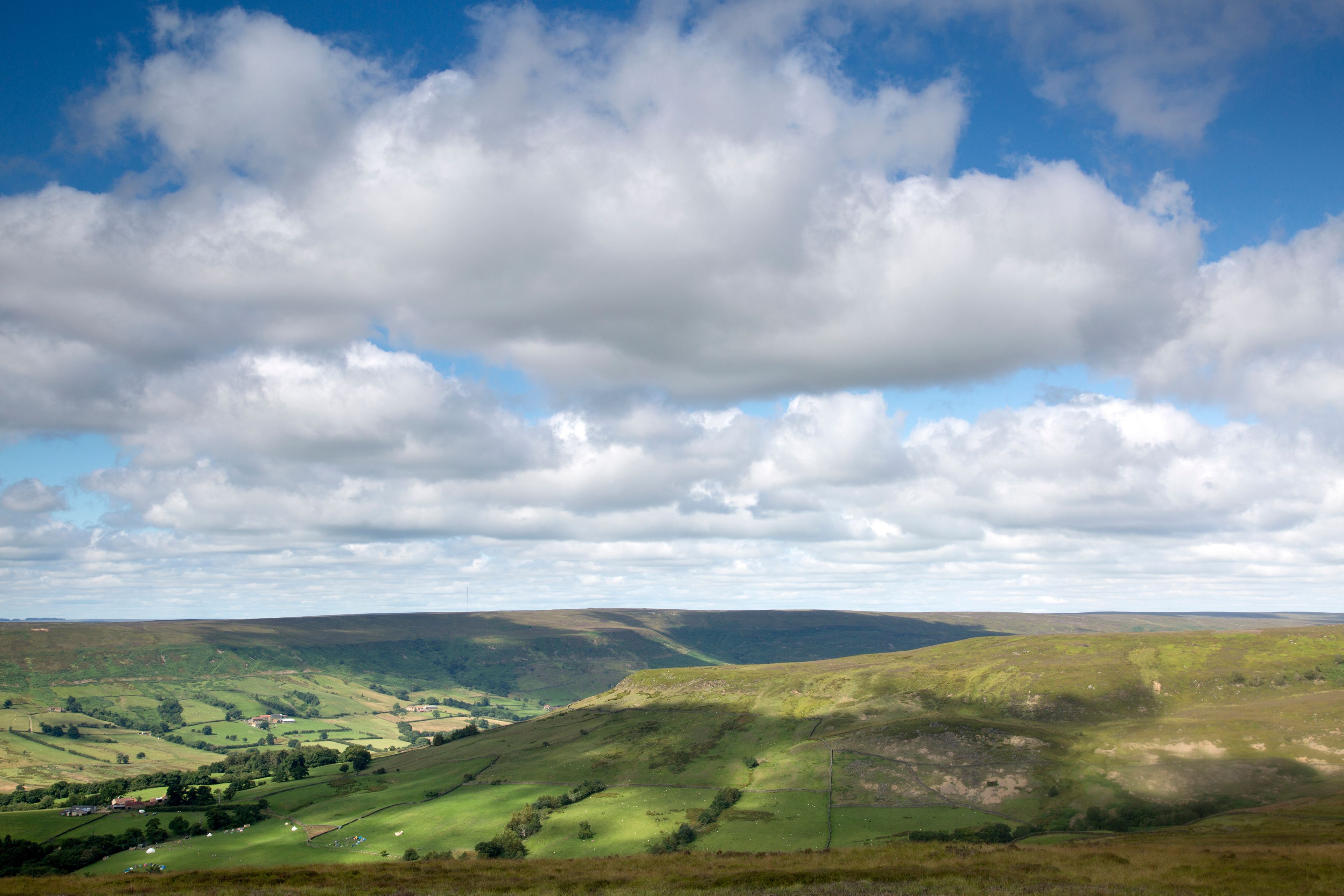 Rolling hills, a valley, and a partly cloudy sky.