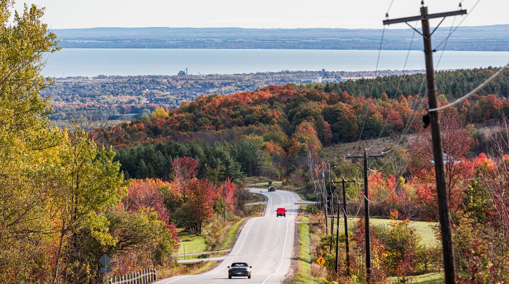 Rolling country road with fall foliage and view of Georgian Bay in Ontario, Canada