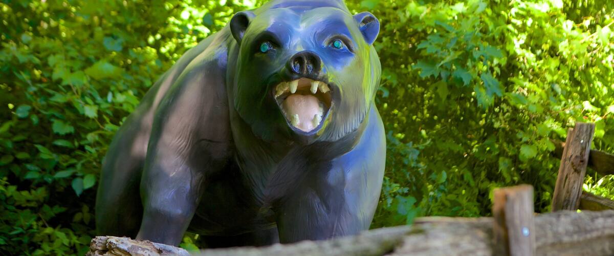 A sculpture of a bear in a forest.