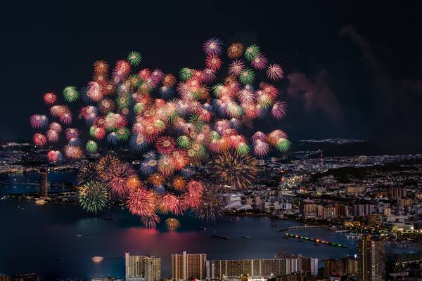 Une vue sur une ville avec un front de mer et un grand feu d’artifice.