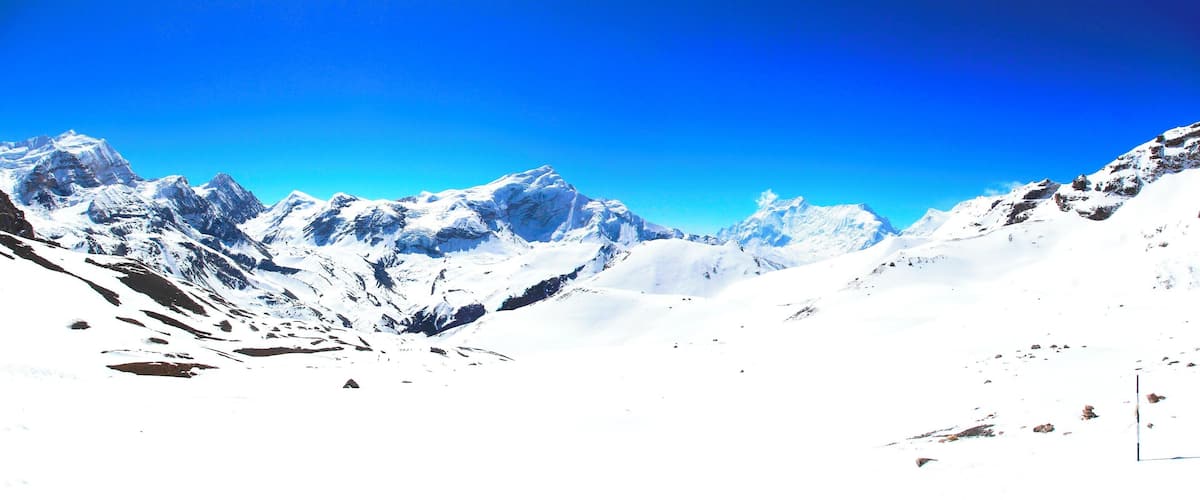 A snow-covered mountain range with clear blue skies.