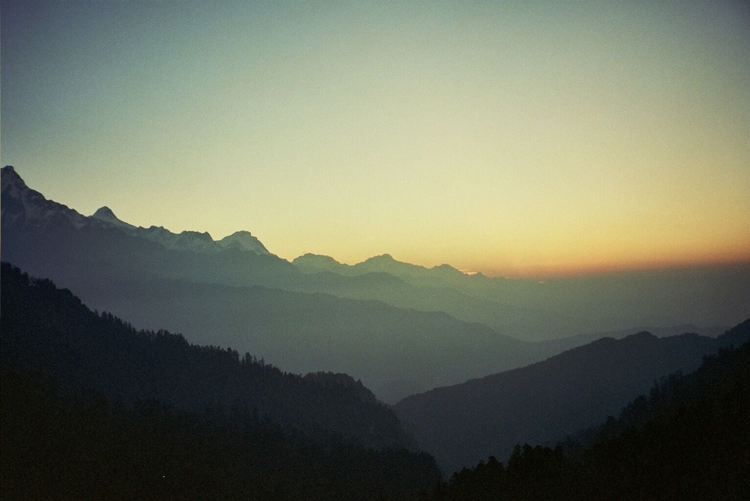 A mountain range at sunrise with a clear sky.