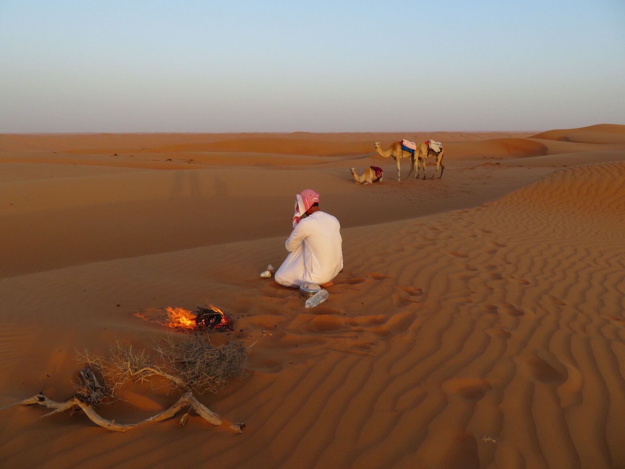 We spent a couple nights in one of the original Bedouin camps of the Wahiba Sands in Oman. This evening we rode camels into the dunes until we were perched high to watch the sunset and enjoy fresh coffee and dates with our host.  Seeing him start a fire in the sand with the wind whipping around him was an incredible experience.  #Adventure Photo Contest  #Bedouin #DesertSands