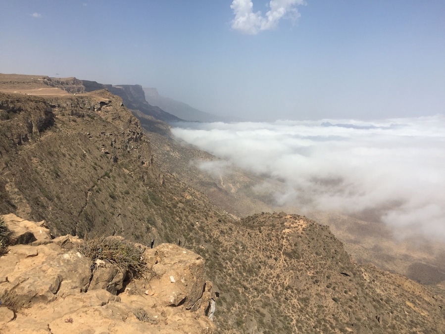 Un paisaje montañoso y accidentado con terreno rocoso y vegetación escasa.
