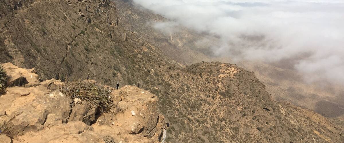 A rugged mountainous landscape with rocky terrain and sparse vegetation.