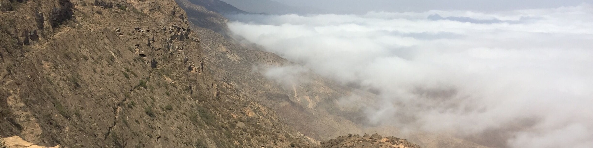 A rugged mountainous landscape with rocky terrain and sparse vegetation.