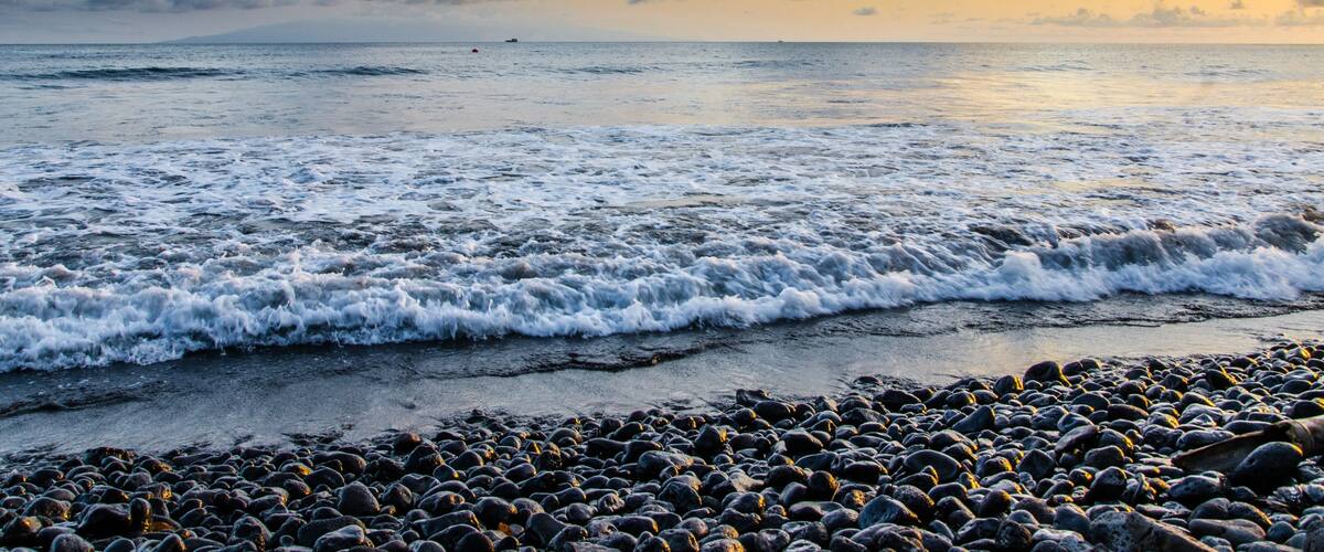 Dramatic coast with rocky volcanic beach, waves and beautiful sunset, Limbe, Cameroon.