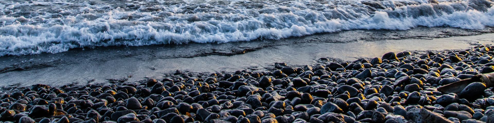 Dramatic coast with rocky volcanic beach, waves and beautiful sunset, Limbe, Cameroon.