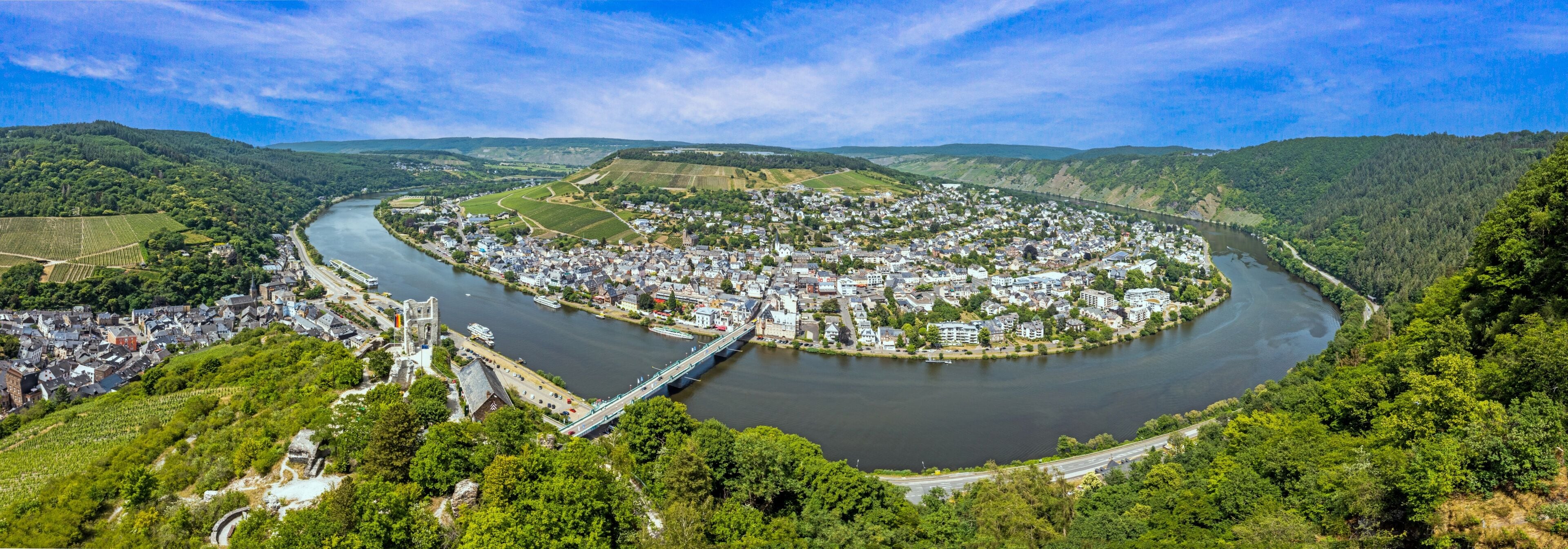 Un fiume serpeggia attraverso una città circondata da colline.