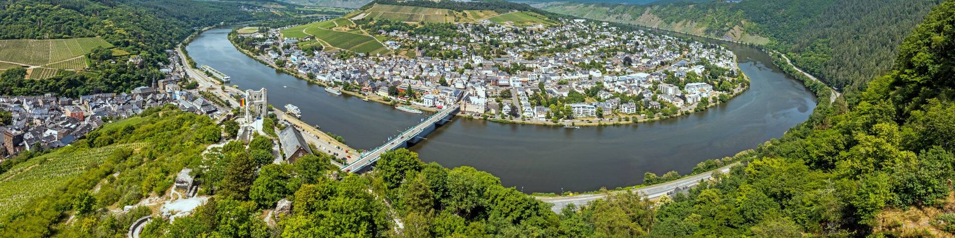 A river winding through a town surrounded by hills.