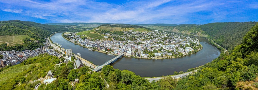 Un fiume serpeggia attraverso una città circondata da colline.