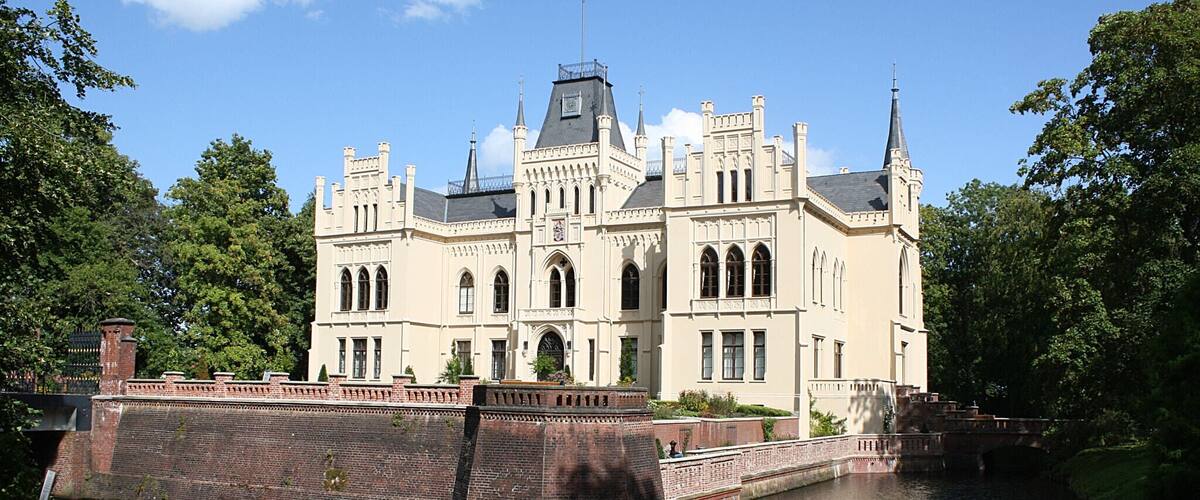 A large, ornate building with a canal in front.