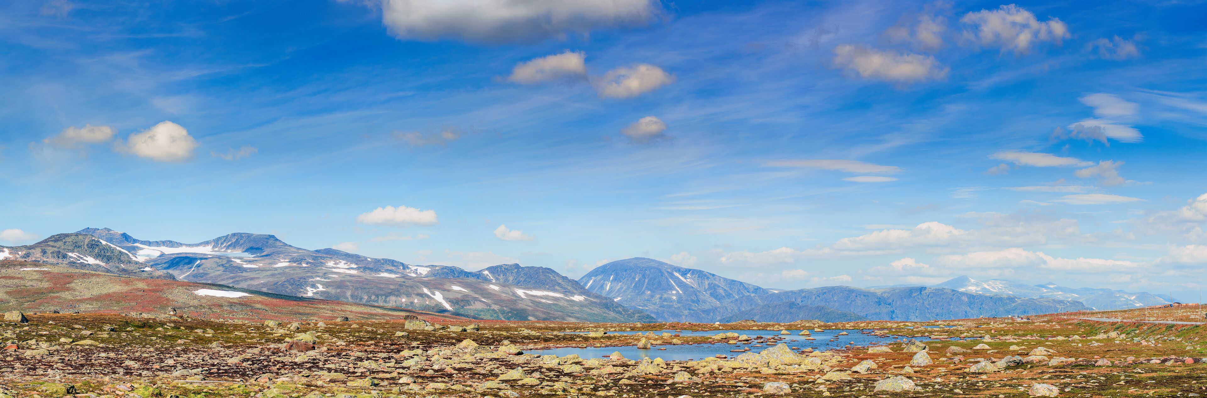 A mountainous landscape with a lake and scattered rocks.
