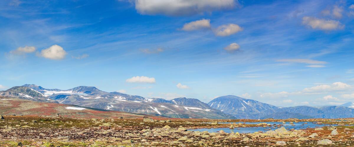 A mountainous landscape with a lake and scattered rocks.
