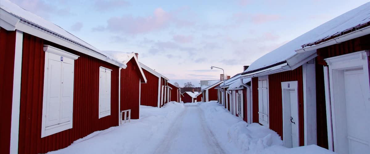 A snow-covered street lined with red buildings.