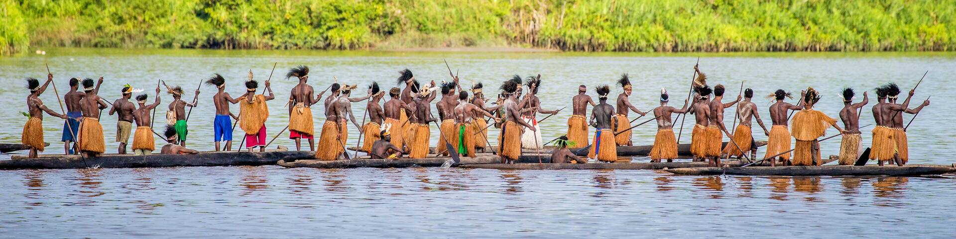 Men Asmat tribe are floating in a canoe on the river. Amanamkay. Village, Asmat province, Indonesia