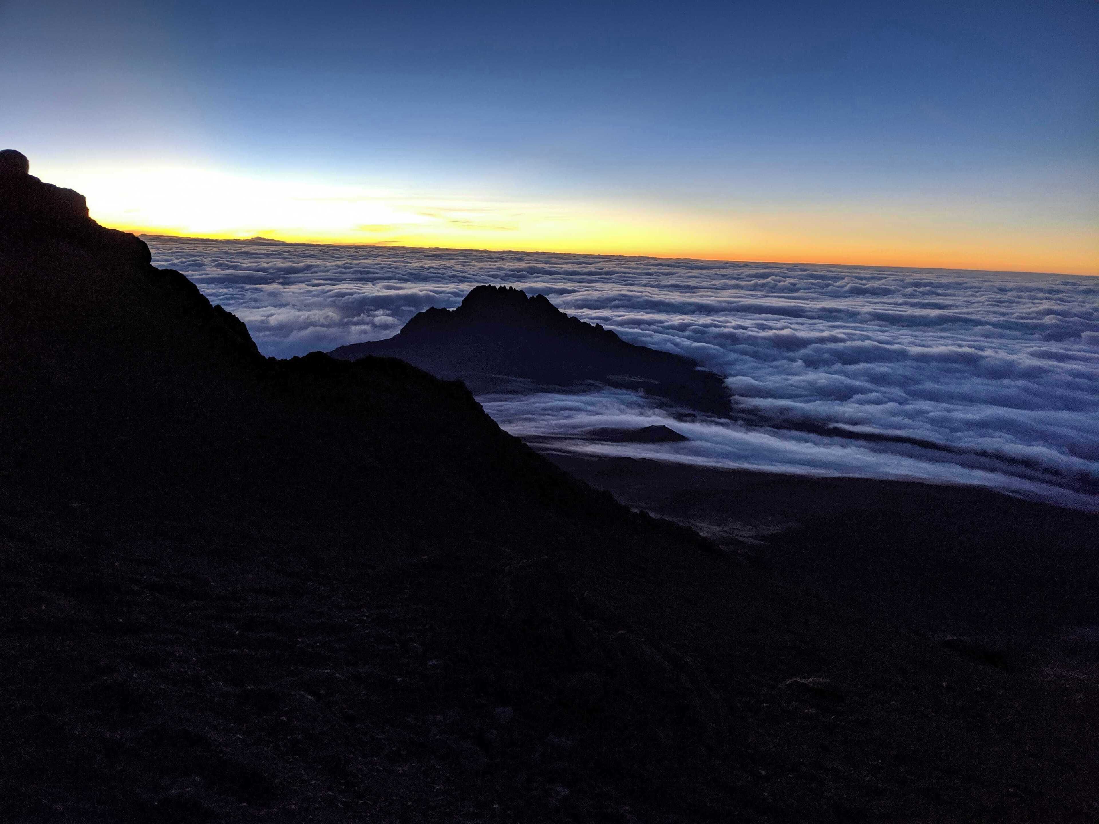 This is looking down on a smaller peak, Mawenzi, from Kibo. At this point you are at 6,000 meters and everything around you is clouds. #LifeAtExpediaG​roup 