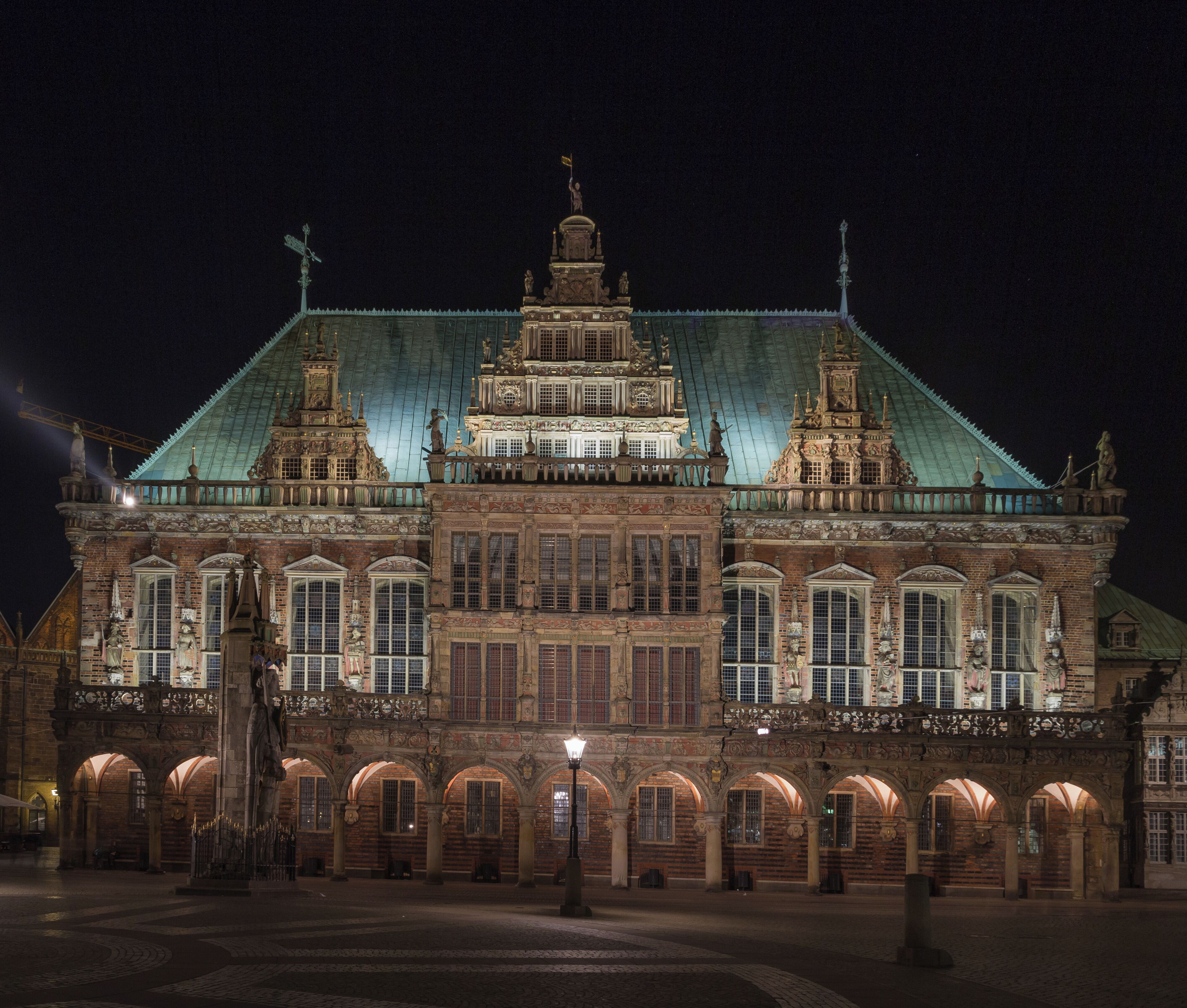 A historic building with intricate architecture, a large central dome, and a statue on the roof.