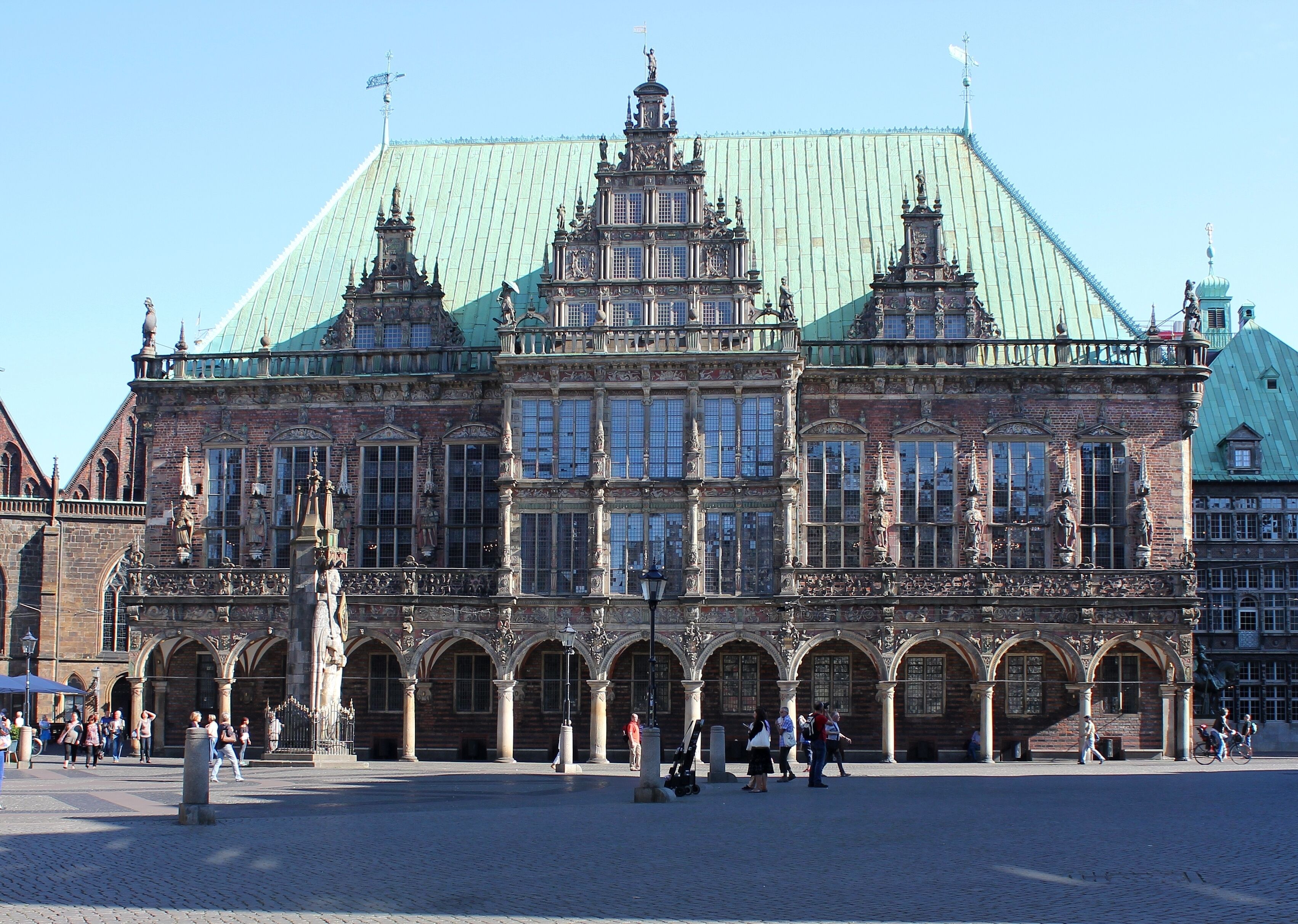 A historic building with ornate architecture, large windows, and a green roof.