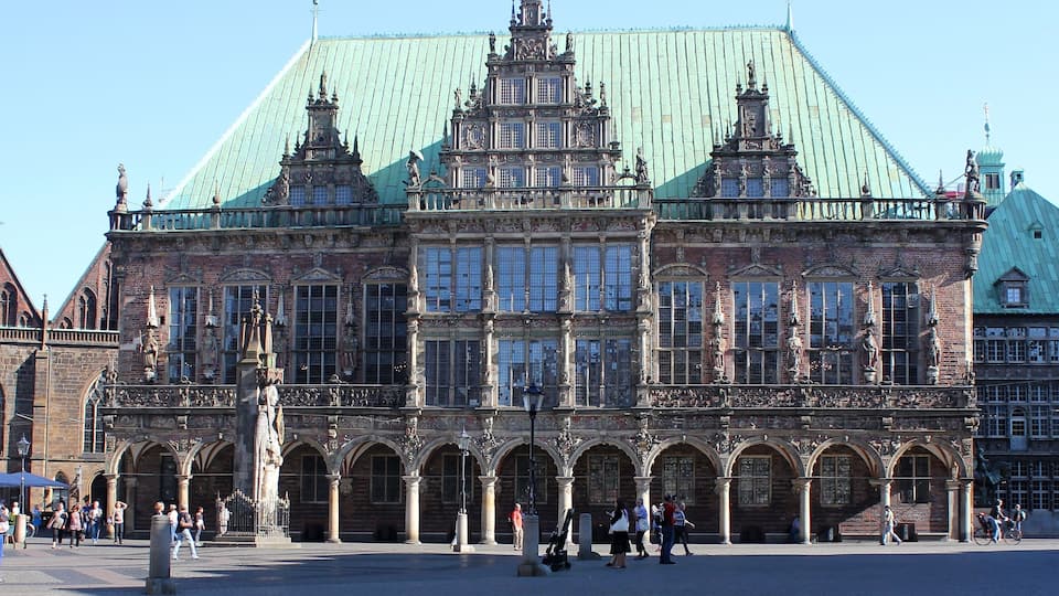 A historic building with ornate architecture, large windows, and a green roof.