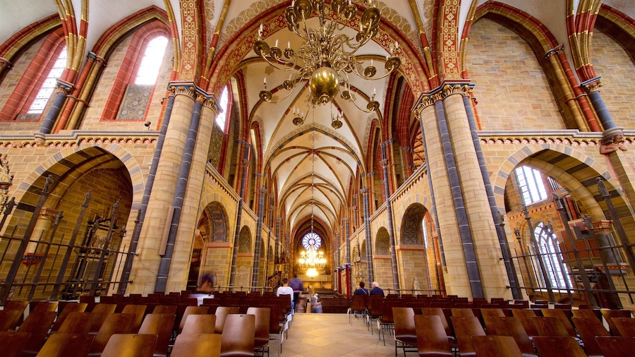 A cathedral interior with high vaulted ceilings, ornate columns, and a large chandelier.