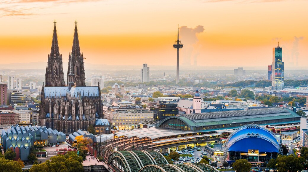A cityscape with a prominent cathedral, modern buildings, and a large stadium.