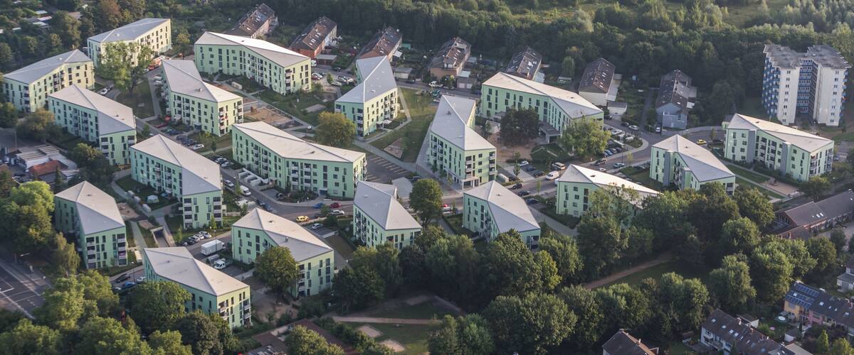 An aerial view of a residential area with modern buildings and green spaces.