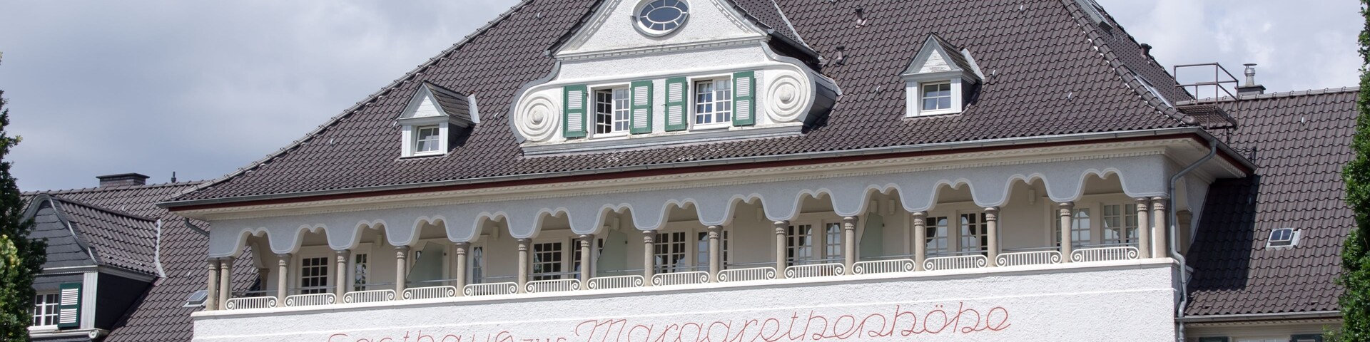 Um edifício branco com persianas verdes e uma placa que diz 'Gasthof zur Marsgarn'.