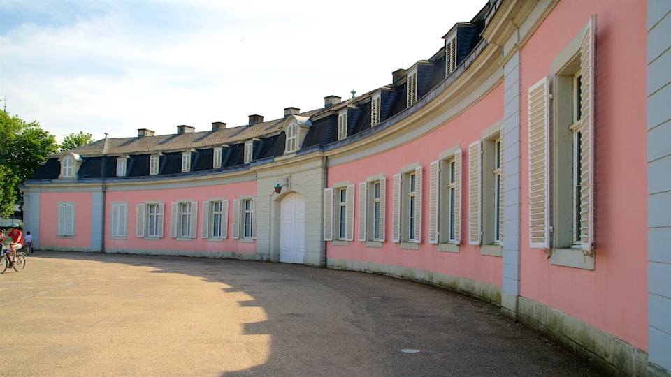 A pink and white building with multiple windows and a curved roof.