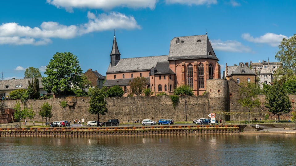 A historic cityscape with a prominent church, a tower, and a river.