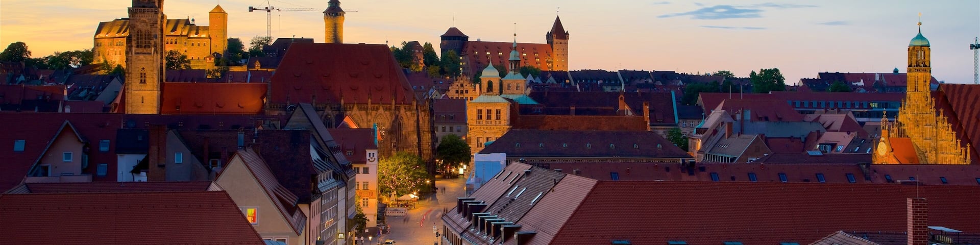 A historic town with medieval architecture, including a prominent church tower and a castle in the background.
