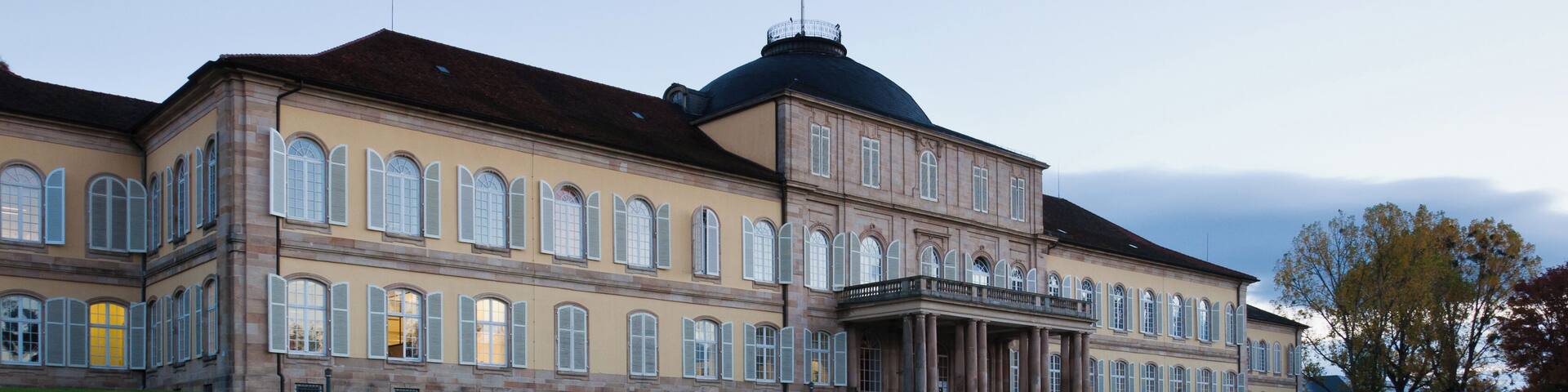 A large, historic building with a central dome and symmetrical architecture.