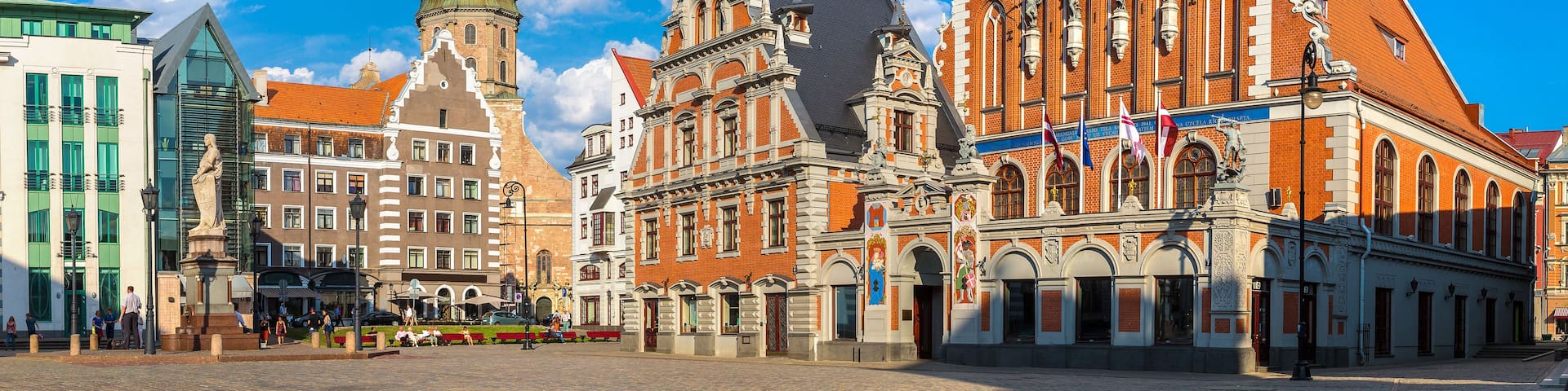 A historic square with a prominent church featuring a tall spire and intricate brickwork.